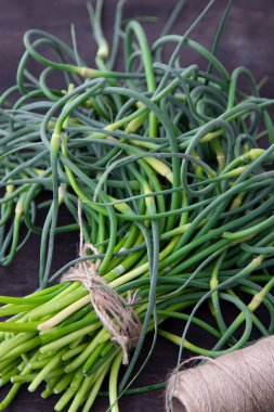 Sarımsaklı oklar. Masada bir sürü yeşillik var. Sebze, sağlıklı vitamin yiyeceği. Salata ve güveç için yeşil saplı fidanlar. Vejetaryen taze otlar, Çin mutfağı..