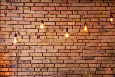 Tungsten lifli eski elektrikli akkor lambalar. Tuğla bir duvarın arkasında. Eski taş zeminin dokusu. Dekoratif vintage dizayn edison ampulleri farklı şekillerde. Antika