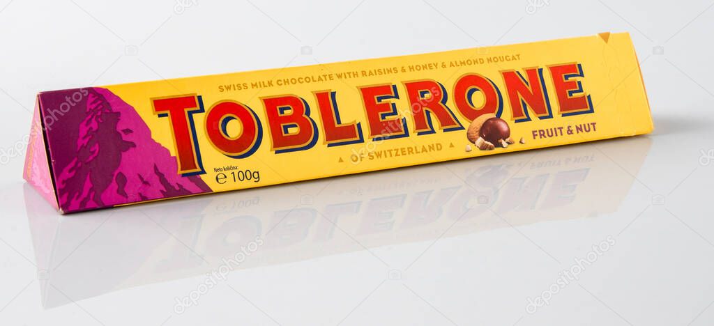 Toblerone Swiss chocolate with raising, honey, almond nougat. New package mountain logo on pink background. Candy sweets are a classic souvenir of Switzerland, Mondelez. Kyiv, Ukraine - July 10, 2023.