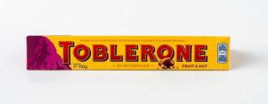 Üzümlü Toblerone İsviçre çikolatası, tatlım, bademli fındıklı. Pembe arka planda yeni paket dağ logosu. Şekerlemeler İsviçre 'nin klasik bir hatırasıdır Mondelez. Kyiv, Ukrayna - 10 Temmuz 2023.