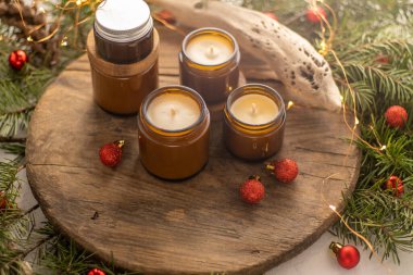 Soya mumları cam kavanozlarda yanar. Evdeki rahatlık. Kahverengi kavanozdaki mum. Koku ve ışık. Kokulu el yapımı mum. Aroma terapisi. Noel ağacı ve kış havası. Hoş bir dekor. Şenlikli çelenk dekorasyonu