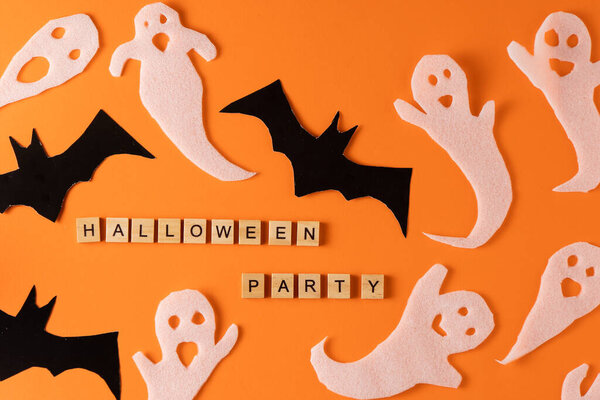 White ghosts and bat craft for Halloween party. Wrapping paper ghost on orange background top view. Cartoon creepy Whisper. DIY hand made. Set boo characters. Word wooden letter phrase.