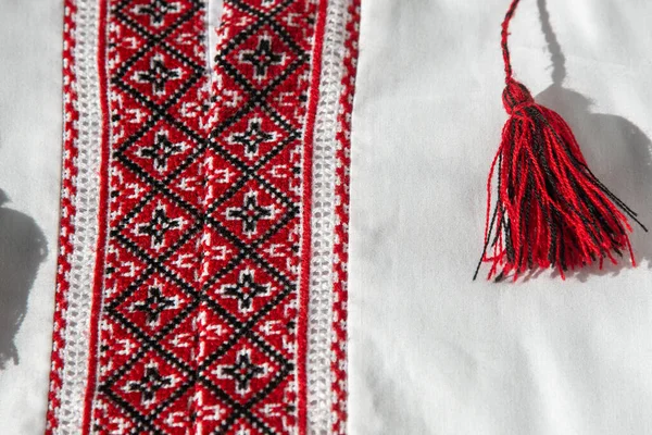 Ukrainian clothes embroidered shirt. Red orange and black threads background. Vyshyvanka is a symbol of Ukraine. Embroidery cross stitching. National Ukrainian stitch. Traditional clothing symbol.