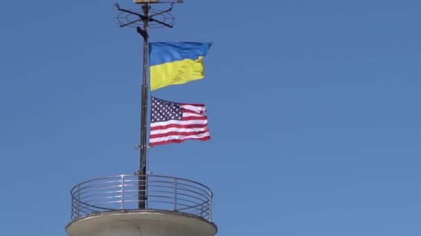 乌克兰和美国的国旗在蓝天的映衬下飘扬 国家象征 乌克兰蓝色和黄色的国旗 室外风天 — 图库视频影像