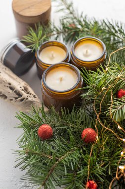 Soya mumları cam kavanozlarda yanar. Evdeki rahatlık. Kahverengi kavanozdaki mum. Koku ve ışık. Kokulu el yapımı mum. Aroma terapisi. Noel ağacı ve kış havası. Hoş bir dekor. Şenlikli çelenk dekorasyonu