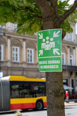 Tahliye için toplanma noktasını gösteren yeşil bir işaret. Buluşma noktası için bir işaret. Sivil Savunma Şehri Caddesi. Toplanma noktası tahliye yeri. Varşova, Polonya - 27 Temmuz 2023