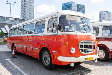 Eski kırmızı ve mavi Skoda otobüsü. Çekoslovakyalı Skoda RTO 706 Karosa modeli. Turist otobüsleri klasik model. Eski şehrin caddesi bir turistik cazibedir. Polonya, Varşova - 27 Temmuz 2023.