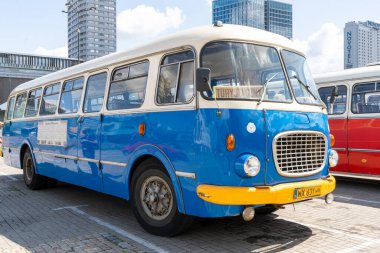 Eski kırmızı ve mavi Skoda otobüsü. Çekoslovakyalı Skoda RTO 706 Karosa modeli. Turist otobüsleri klasik model. Eski şehrin caddesi bir turistik cazibedir. Polonya, Varşova - 27 Temmuz 2023.