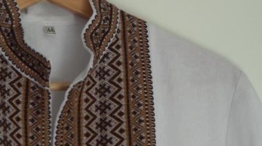 Ukrayna giysileri işlemeli gömlek. Kahverengi bej ve beyaz iplikler arka planda. Vyshyvanka Ukrayna 'nın sembolü. Nakış haçı dikişleri. Ulusal Ukrayna dikişi. Geleneksel kıyafetler