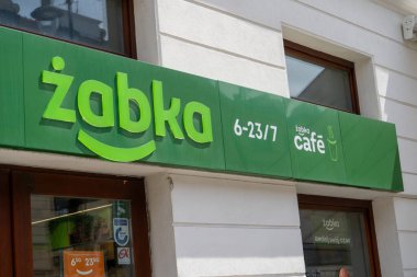Polonya bakkal tabelası ZABKA kafe. Yeşil tabela süpermarketi. Ev binası cephesi. Sokak dükkânı. Varşova, Polonya - 26 Temmuz 2023.