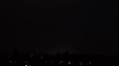 Gece gökyüzünde gök gürültülü fırtına. Kara gökyüzünde şimşekler çakıyor. Doğa. Şehirde fırtına ve kasırga var. Kara yağmur bulutları. Eve yıldırım düştü..
