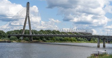 Stadyum manzarası. Vistula Nehri üzerindeki köprü. Şehir trafiği. Arabalar yolda. Şehir manzarası. Panorama manzaralı. Bulutlu gökyüzü. Varşova, Polonya. Yaz gününde yeşil ağaç. Varşova, Polonya - 27.07.2023.
