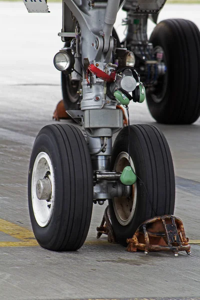航空機の着陸ギアと鉄のサポートシューズ タイヤのタイヤ 駐車場のハンドリング エアポートライフ — ストック写真