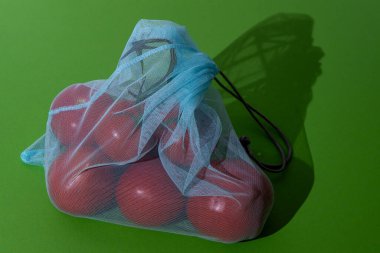Eco bag for shopping in the store. Mesh replacement for plastic bag. Eco-friendly concept background. Zero waste. Tomatoes vegetables in bag.