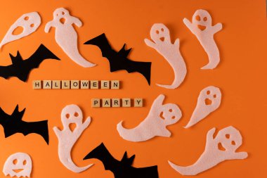 White ghosts and bat craft for Halloween party. Wrapping paper ghost on orange background top view. Cartoon creepy Whisper. DIY hand made. Set boo characters. Word wooden letter phrase.