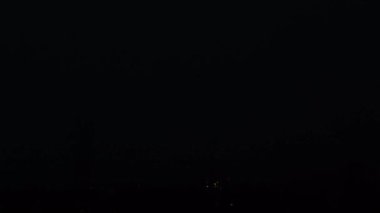 Gece gökyüzünde gök gürültülü fırtına. Kara gökyüzünde şimşekler çakıyor. Doğa. Şehirde fırtına ve kasırga var. Kara yağmur bulutları. Eve yıldırım düştü..