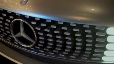 Gümüş Mercedes arabası. Çarpma ve farlar. Kaputta amblem var. Mercedes-Benz lüks lüks birinci sınıf bir araç. Varşova, Polonya - 28.07.2023.