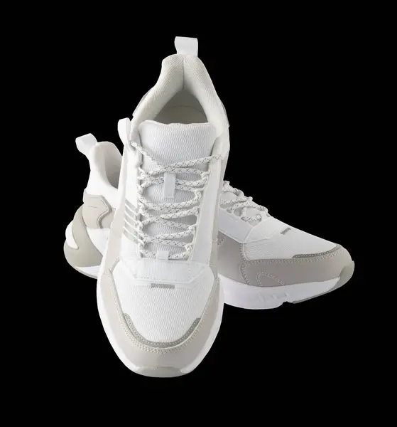 White running shoes. Sport sneakers isolated on black background. A casual, comfortable pair of beige shoes. A new and fashionable pair of sneakers. Cutout.