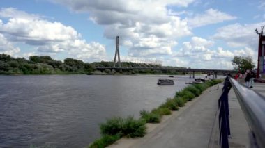 Varşova 'daki Vistula Nehri' nin seti. Gemi kalkıyor. Köprü ve stadyum manzarası. Bulutlu gökyüzü. Açık hava.
