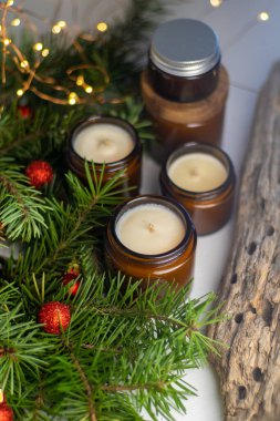 Soya mumları cam kavanozlarda yanar. Evdeki rahatlık. Kahverengi kavanozdaki mum. Koku ve ışık. Kokulu el yapımı mum. Aroma terapisi. Noel ağacı ve kış havası. Hoş bir dekor. Şenlikli çelenk dekorasyonu