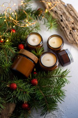 Soya mumları cam kavanozlarda yanar. Evdeki rahatlık. Kahverengi kavanozdaki mum. Koku ve ışık. Kokulu el yapımı mum. Aroma terapisi. Noel ağacı ve kış havası. Hoş bir dekor. Şenlikli çelenk dekorasyonu