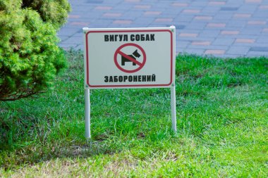 Çimenlikte yeşil çimlerle işaretli. Banner metin köpeği gezdirme yasaklı bir kuruldur. Yazı Ukraynaca yazılmış. Ukrayna, Kyiv - 6 Temmuz 2023