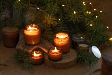 Soya mumları cam kavanozlarda yanar. Evdeki rahatlık. Kahverengi kavanozdaki mum. Koku ve ışık. Kokulu el yapımı mum. Aroma terapisi. Noel ağacı ve kış havası. Sıcak ev dekorasyonu. Şenlikli dekorasyon.