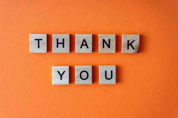 Teşekkür ederim. Sözcük ahşap harflerle sıralanmış. Turuncu düz arkaplan