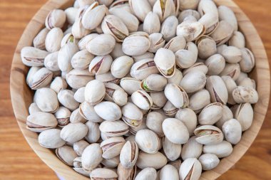 Ahşap bir kasede fıstıklar. Ahşap arka plan. Sağlıklı yemek.