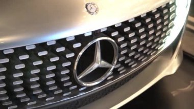 Gümüş Mercedes arabası. Çarpma ve farlar. Kaputta amblem var. Mercedes-Benz lüks lüks birinci sınıf bir araç. Varşova, Polonya - 28.07.2023.