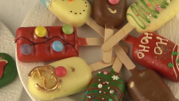 クリスマスデザート スイートフード アイスクリームの形をしたスティックにチーズケーキ 冬に子供が治療する キャンディクリスマスツリー スノーマン サンタクロース ジンジャーブレッドクッキー — ストック動画