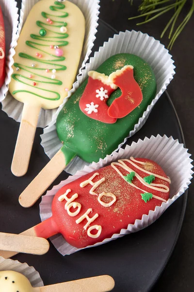 Christmas dessert. Sweet food. Cheesecake on a stick in the shape of ice cream. Childrens treat in winter. Candy Christmas tree Ho Ho Ho. Gingerbread cookies.