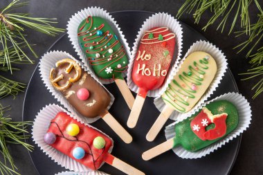 Noel tatlısı. Tatlı yemek. Dondurma şeklinde çubuk üzerinde cheesecake. Çocuklar kışın ısmarlar. Şeker Noel ağacı, kardan adam, geyik ve Noel Baba. Zencefilli kurabiye..