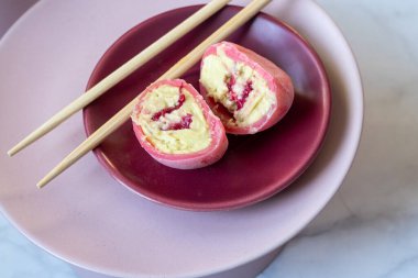 Krema ve böğürtlenli pembe mochi tatlı. Kes.