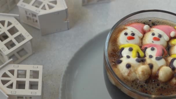 マシュマロでコーヒーを飲む サンタクロースの帽子で マシュマロの雪だるま 冬のドリンク クリスマスの甘い食べ物 トップビュー — ストック動画