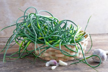 Sarımsaklı oklar. Masada bir sürü yeşillik var. Sebze, sağlıklı vitamin yiyeceği. Salata ve güveç için yeşil saplı fidanlar. Vejetaryen taze otlar, Çin mutfağı..