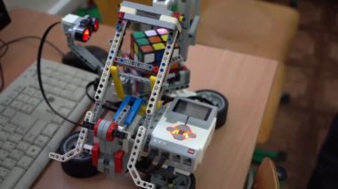 Robot bilimi dersi için el işi. LEGO setinden yapılmış bir robot ve motor Rubiks küpünü çözüyor. Okulda basit oyuncak modelleri ve programların geliştirilmesi. Ukrayna, Kyiv - 16 Aralık 2023