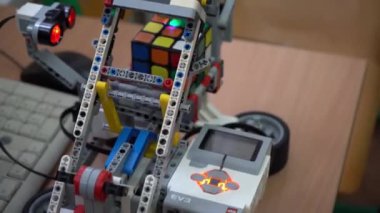 Robot bilimi dersi için el işi. LEGO setinden yapılmış bir robot ve motor Rubiks küpünü çözüyor. Okulda basit oyuncak modelleri ve programların geliştirilmesi. Ukrayna, Kyiv - 16 Aralık 2023