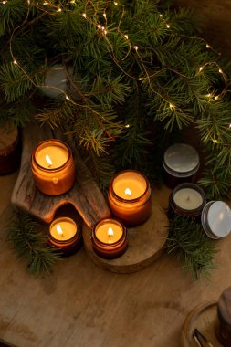 Soya mumları cam kavanozlarda yanar. Evdeki rahatlık. Kahverengi kavanozdaki mum. Koku ve ışık. Kokulu el yapımı mum. Aroma terapisi. Noel ağacı ve kış havası. Sıcak ev dekorasyonu. Şenlikli dekorasyon.