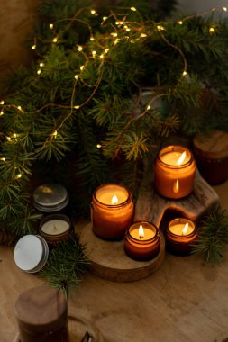 Soya mumları cam kavanozlarda yanar. Evdeki rahatlık. Kahverengi kavanozdaki mum. Koku ve ışık. Kokulu el yapımı mum. Aroma terapisi. Noel ağacı ve kış havası. Sıcak ev dekorasyonu. Şenlikli dekorasyon.