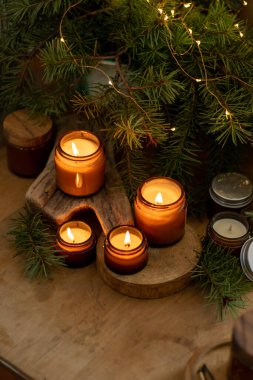 Soya mumları cam kavanozlarda yanar. Evdeki rahatlık. Kahverengi kavanozdaki mum. Koku ve ışık. Kokulu el yapımı mum. Aroma terapisi. Noel ağacı ve kış havası. Sıcak ev dekorasyonu. Şenlikli dekorasyon.