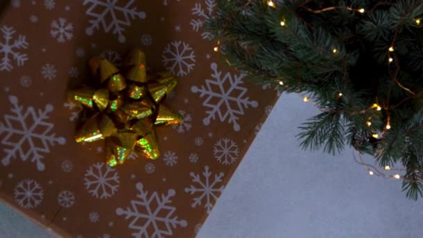 金色缎带在礼物上鞠躬 圣诞树下的盒子夜灯 — 图库视频影像
