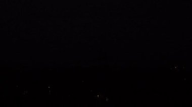 Gece gökyüzünde gök gürültülü fırtına. Kara gökyüzünde şimşekler çakıyor. Doğa. Şehirde fırtına ve kasırga var. Kara yağmur bulutları. Eve yıldırım düştü..