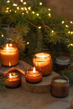 Soya mumları cam kavanozlarda yanar. Evdeki rahatlık. Kahverengi kavanozdaki mum. Koku ve ışık. Kokulu el yapımı mum. Aroma terapisi. Noel ağacı ve kış havası. Sıcak ev dekorasyonu. Şenlikli dekorasyon.