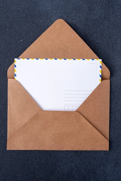 Open craft brown envelope and postcard form. Letter with copy space
