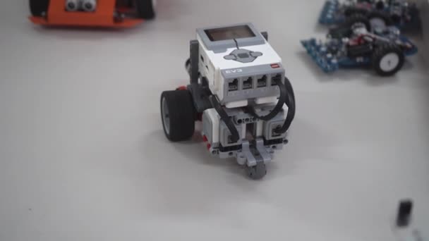 ロボット工学クラスのためのクラフト レゴの建設キットやモーターから作られたロボットカー 異なるセンサーを搭載したシンプルなおもちゃモデルの開発 ウクライナ キエフ 2023年12月16日 — ストック動画