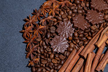 Yemek arkaplanı. Kahve çekirdekleri, tarçın çubukları, anason yıldızları ve çikolatalı şekerler..