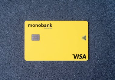 Universal Bank 'tan Monobank Ukrayna bankasının kredi kartı. Sarı kart ve çip. Ukrayna, Kyiv - 17 Mart 2023.