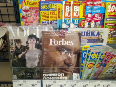 Gazeteler ve dergilerle dolu bir dükkanda tezgah. Vogue ve Forbes dergileri. Ukrayna, Kyiv - 18 Mart 2024.