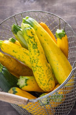 Sarı yeşil leopar benekli kabak. Sebzeler masada. sebze iliği hasadı. Yemek arkaplanı. Taze kabak, kesilmiş yaz kabağı. Kabak topladım. Mutfakta hayat devam ediyor.
